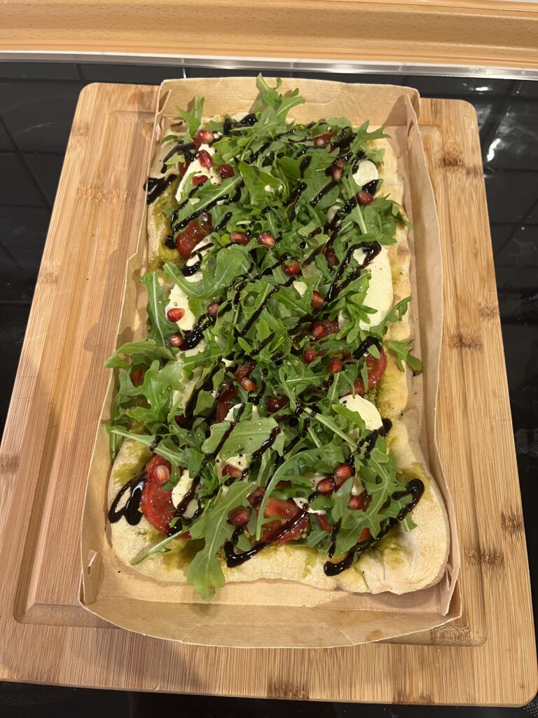Belegte Pinsa mit Tomaten, Rucola & Granatapfel